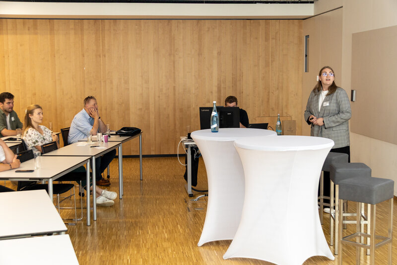 Eine junge Frau steht vor einer Gruppe und präsentiert. | © FH Kufstein Tirol