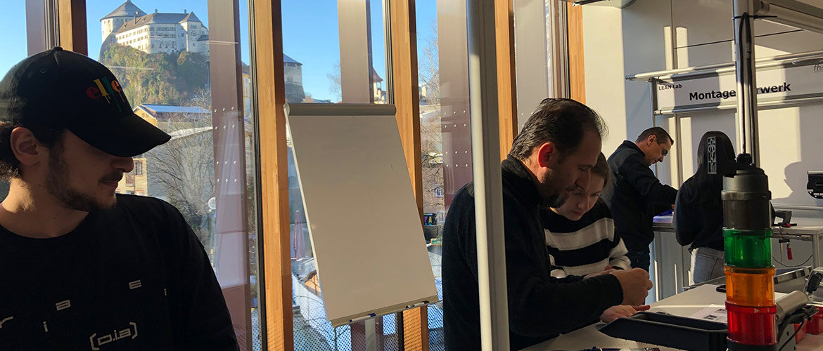 Teilnehmende der Lean-Management-Fortbildung im FH-Labor mit Blick auf Festung Kufstein.