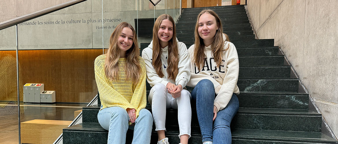 Praxisprojekt zur Gewaltprävention im Kindergarten von Studentinnen der FH Kufstein Tirol. Drei Studentinnen der FH Kufstein Tirol sitzen auf einer Treppe im Hochschulgebäude.