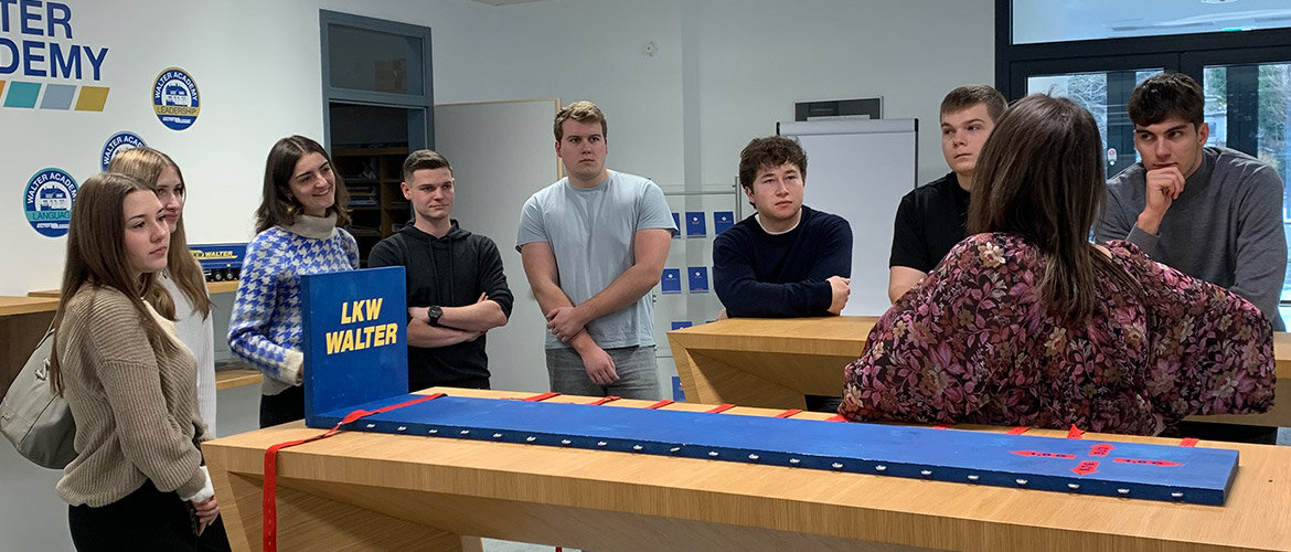 Studierende der FH Kufstein Tirol lauschen in den Geäuden von LKW Walter den Ausführungen einer Mitarbeiterin.