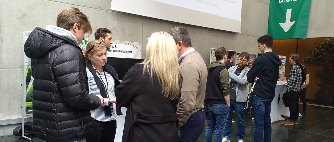 Besucher im Gespräch beim Open House Event in der Aula.