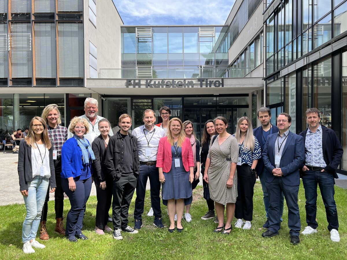 Teilnehmende des Tourismus-Workshops an der FH Kufstein Tirol posieren vor dem Gebäude der Fachhochschule.
