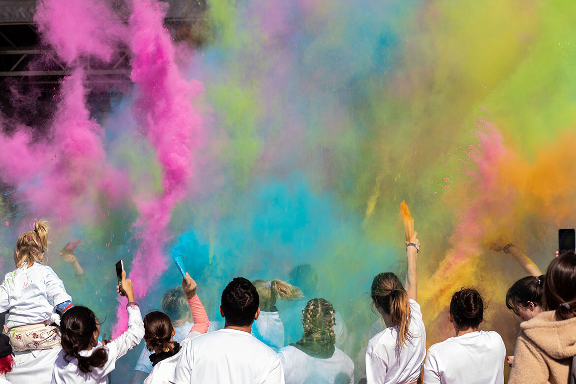 Teilnehmer werfen das Farbpulver in die Luft