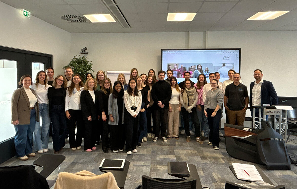 Gruppenfoto von Studierenden mit Betreuer vor einem Bildschirm