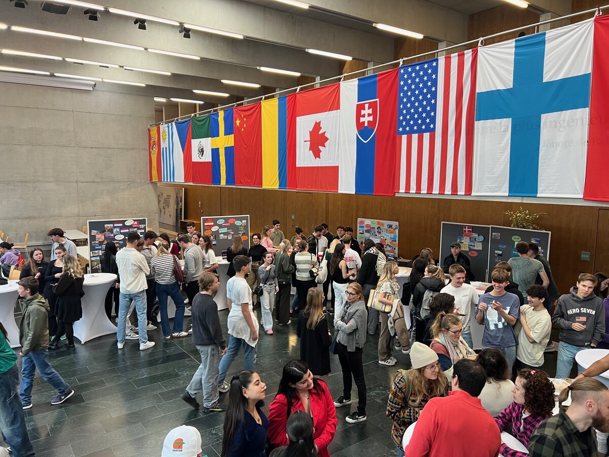 Exchange Fair 2024 Ein großer Raum mit vielen Menschen und den Flaggen zahlreicher Länder.