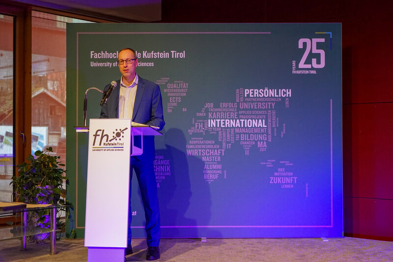 Prof. (FH) Dr. Mario Döller hält eine Rede auf dem Podium im Festsaal anlässlich der Verleihung der Leistungsstipendien an der FH Kufstein Tirol.
