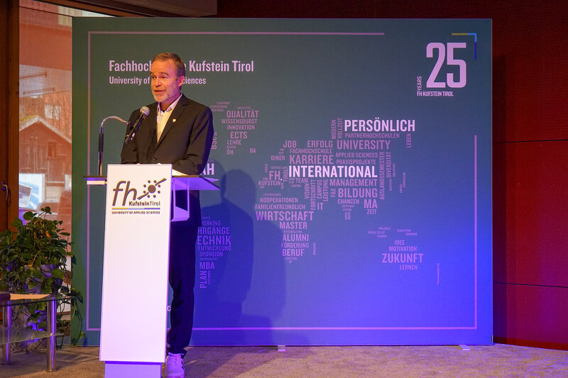 Prof. (FH) Dr. Wolfgang Reitberger hält eine Rede auf dem Podium im Festsaal anlässlich der Verleihung der Leistungsstipendien an der FH Kufstein Tirol.