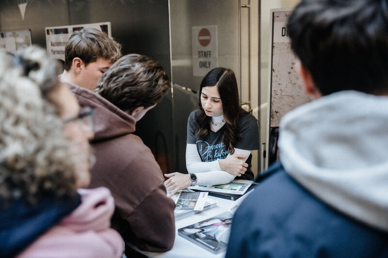 Gruppe von Gästen lässt sich an Infostand der FH Kufstein Tirol beraten