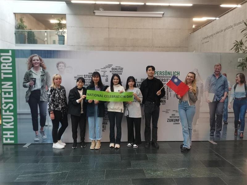 Austauschstudierente vor dem International Banner in der Aula