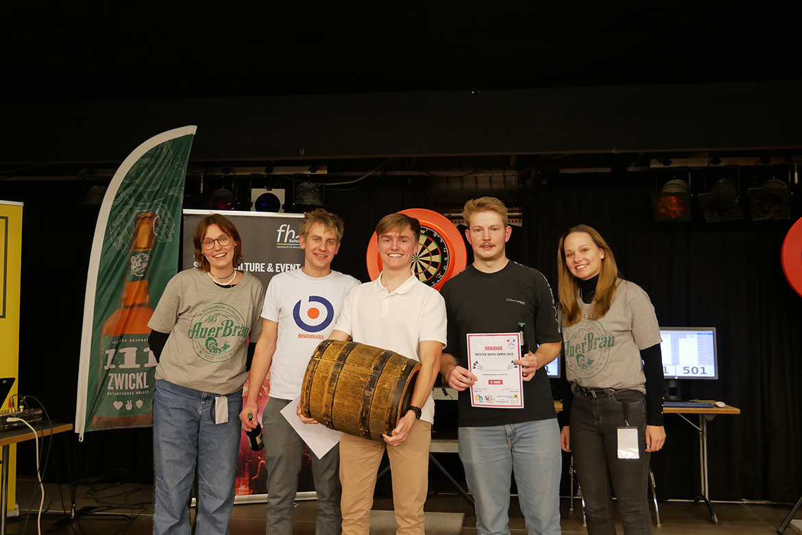 Kufstein Darts Games Siegerehrung Hobbyspieler Sieger:innen stehen nebeneinander mit einem Fass in der Mitte und Preisen
