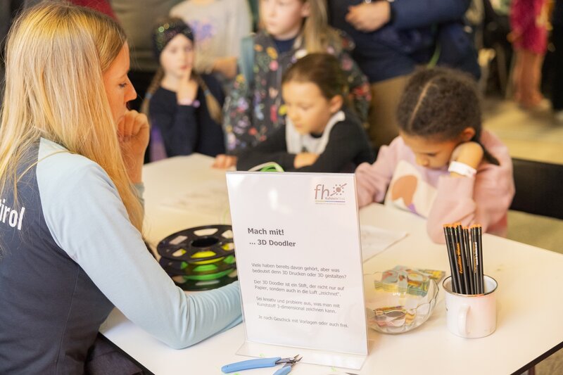 Lena von hinten mit Kindern am Tisch