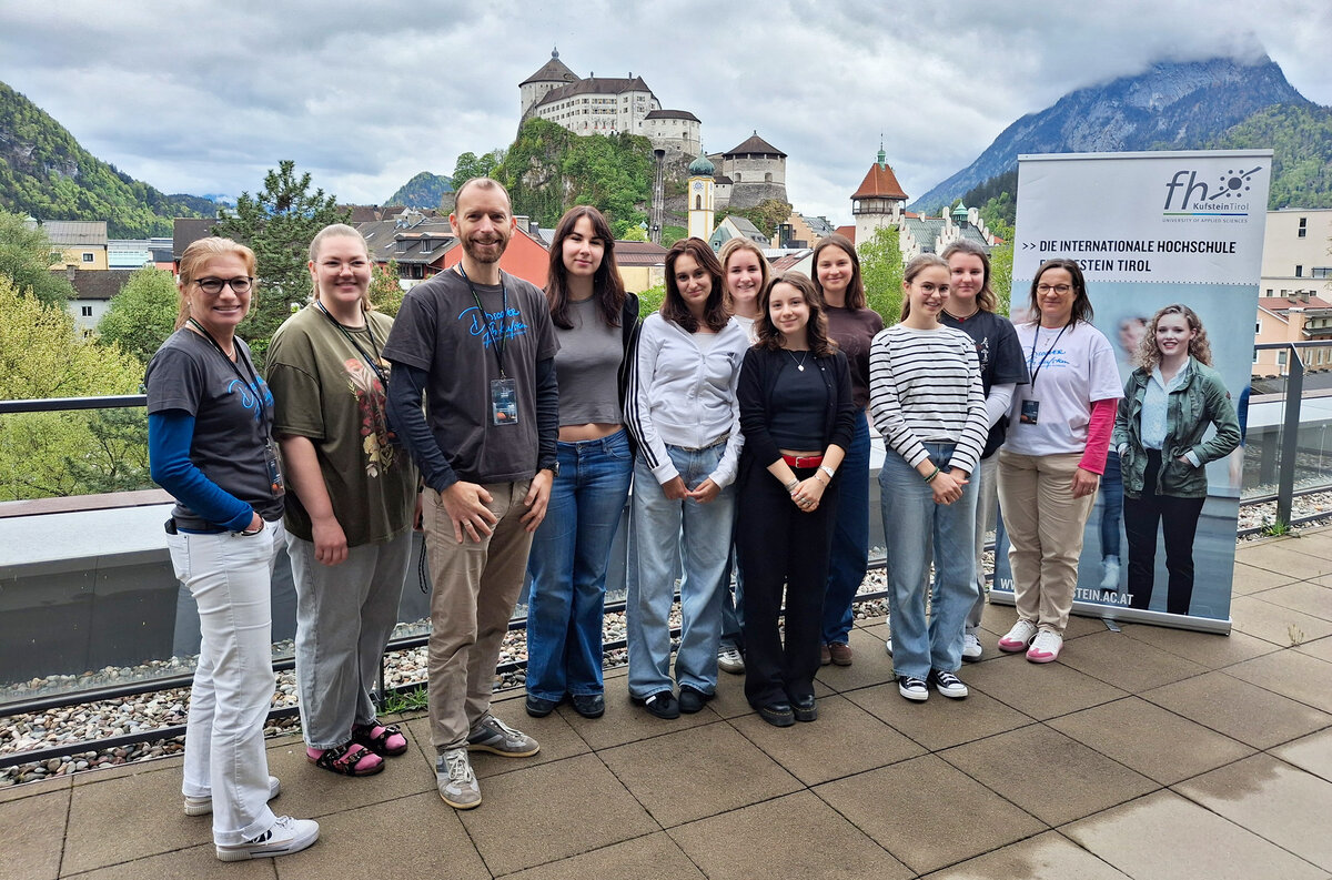 Gruppe auf der Dachterasse der FH Kufstein mit Festung als Hintergrund 