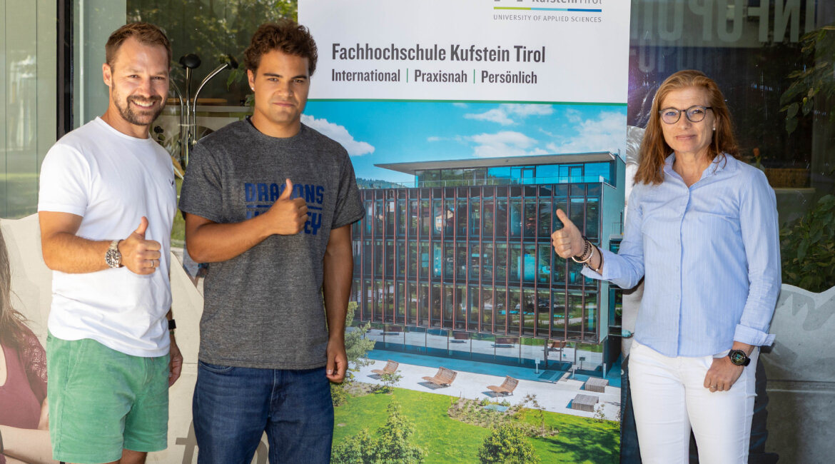 Gruppenfoto vor der FH Kufstein Tirol: Roland Luchner (HC Kufstein Dragons), Spieler Aleksi Airaksinen und FH-Vizerektorin Claudia Van der Vorst.
