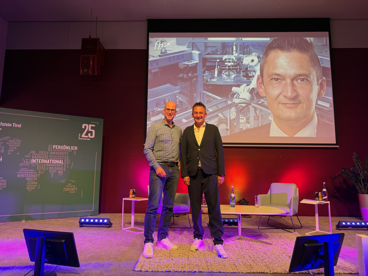 Managementforum Hannes Auer Peter Dietrich mit Hannes Auer auf der Bühne und im Hintergrund ein Portrait von Auer
