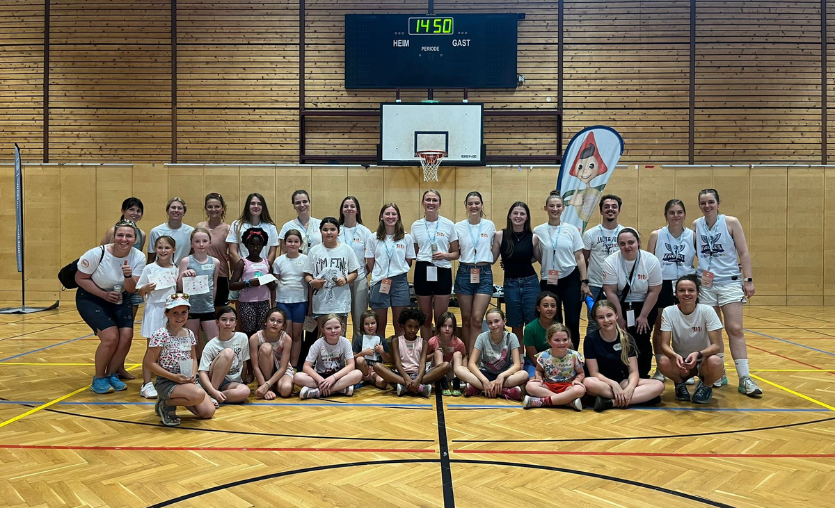 Mädels stehen als Gruppe zusammen in einer Sporthalle