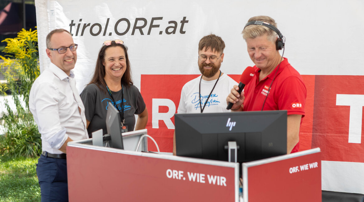 Vier Personen bei einem Live-Interview der ORF-Sommerfrische, zwei mit „Discover Kufstein“-T-Shirts, ein Moderator mit Mikrofon und Kopfhörern.