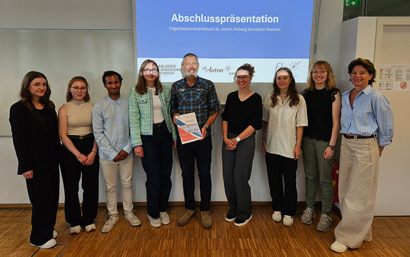 Projektmitglieder stehen vor einer Wand zusammen.