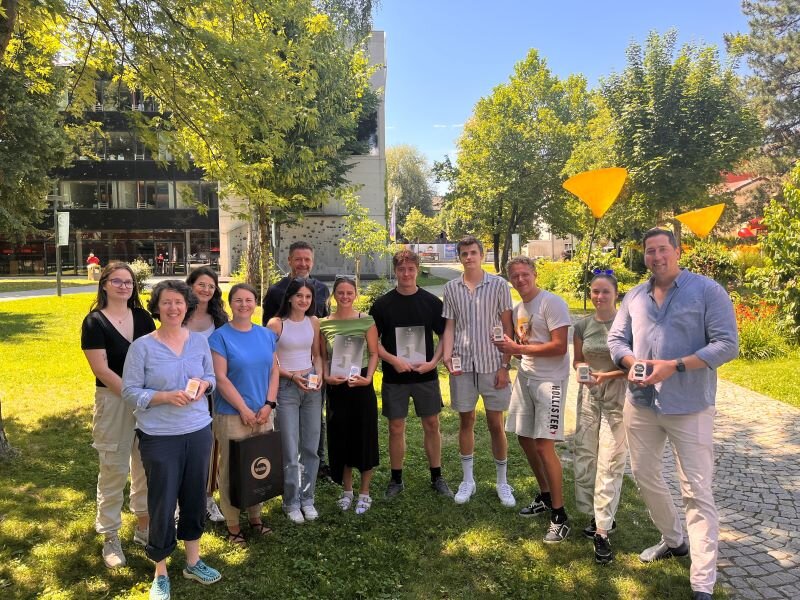 Gruppenfoto mit der Firma Walde | Praxisprojekt Studierende der FH Kufstein zusammen mit Vertretern der Alois Walde GmbH im Innenhof der Fachhochschule.