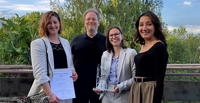 Vier Personen, darunter drei junge Frauen und ein Mann, stehen lächelnd im Freien. Eine Frau hält eine Urkunde mit der Aufschrift „Future Talent Award 2025“, eine andere ein gläsernes Award-Trophäe.