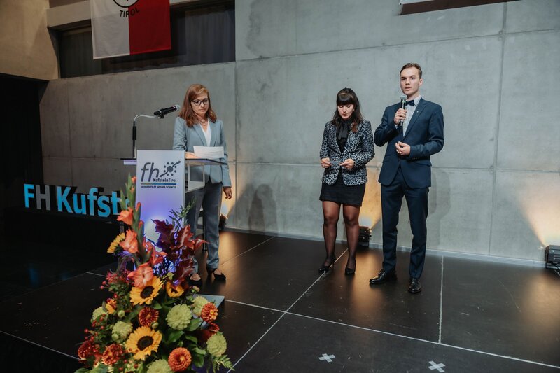Sponsion 2025 - Verlesung Akademische Gelöbnisformel Prof. (FH) Dr. Claudia Van der Vorst, MBA und Spondierende auf dem Podium beim Verlesen der Akademischen Gelöbnisformel.
