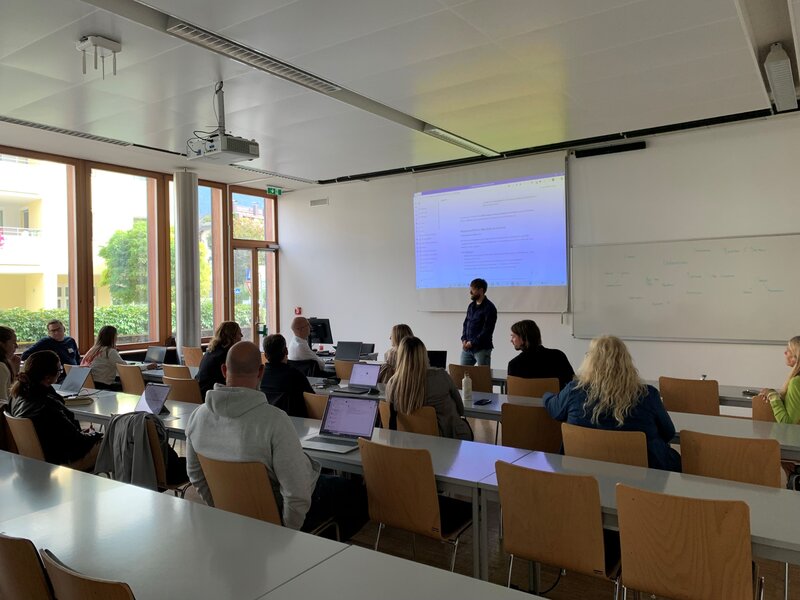 Thomas Schmiedinger in einem Vorlesungsraum mit Teilnehmenden.