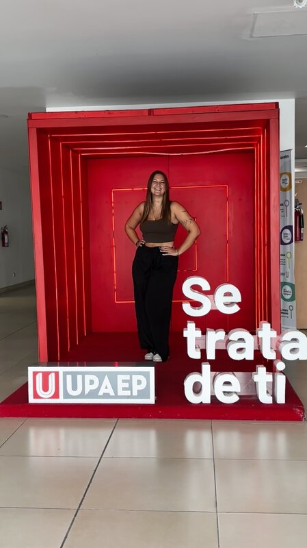 Magdalena steht in einer Fotobox mit der spanischen Schrift: Es geht um dich.