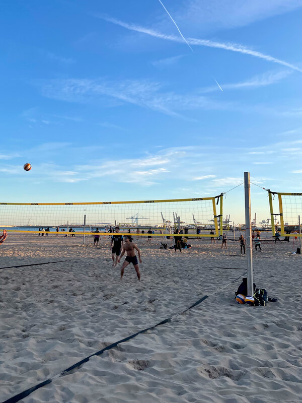 Personen spielen am Strand Beachvolleyball