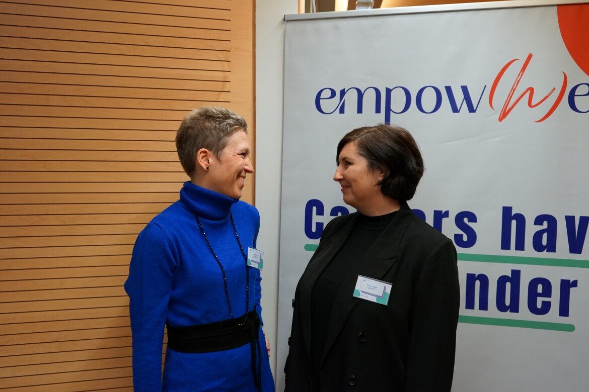 Kristina Kampfner und Tatjana Gerst bei EmpowHER Kristina Kampfner und Tatjana Gerst stehen sich vor einem EmpowHER-Roll-up gegenüber und lächeln sich an.