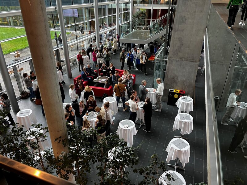 Blick von oben auf die Personen in der Aula.