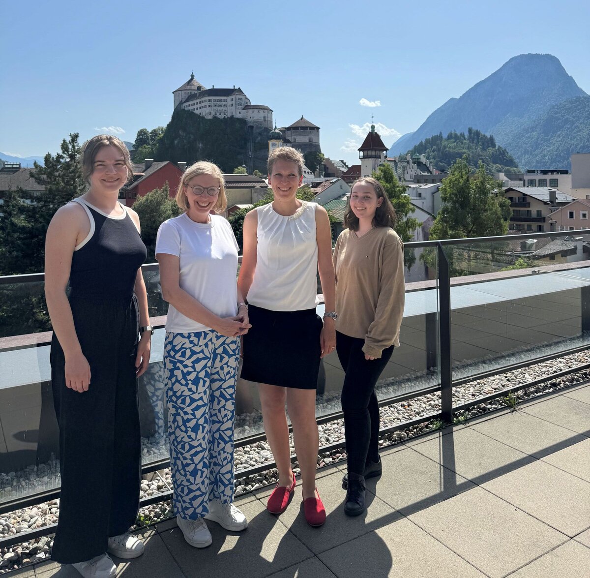 Personen stehen auf einer Terrasse, im Hintergrund die Festung von Kufstein.