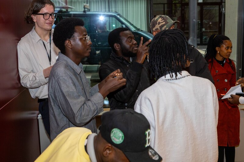 Personen stehen zusammen und blicken nach rechts.