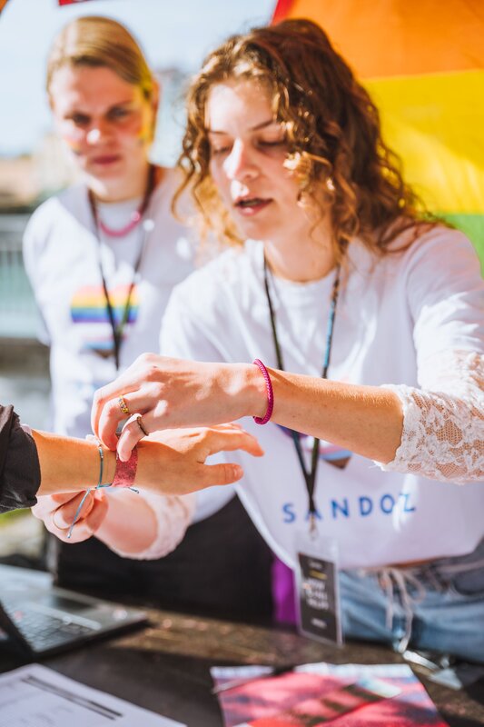 Eine Person bindet ein Band um den Arm einer anderen Person.