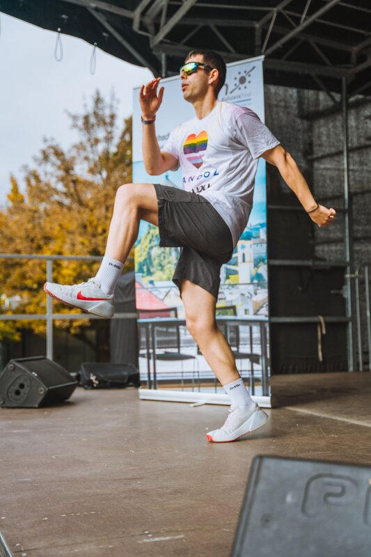 Eine Person steht auf einer Bühne und hebt ein Bein.