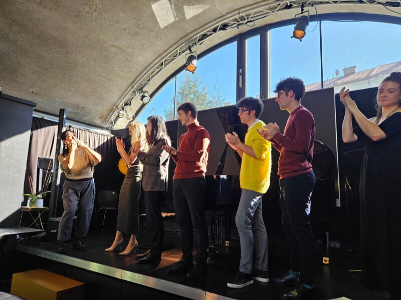 Personen stehen auf einer Bühne.