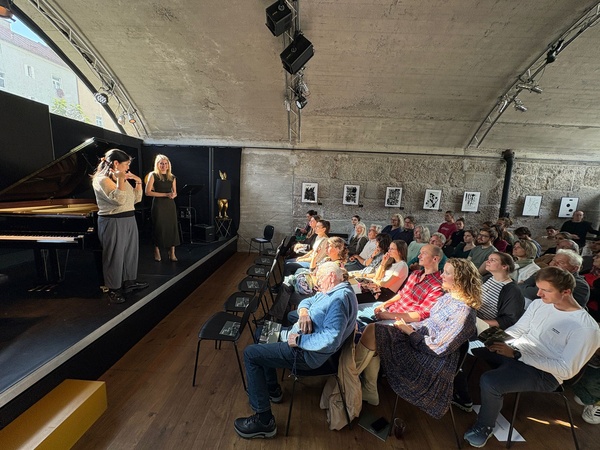 Zwei Personen stehen auf einer Bühne und sprechen zum sitzenden Publikum. | © FH Kufstein Tirol