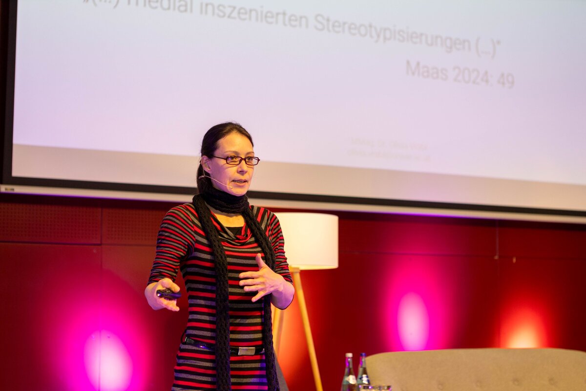 Person steht auf einer Bühne.