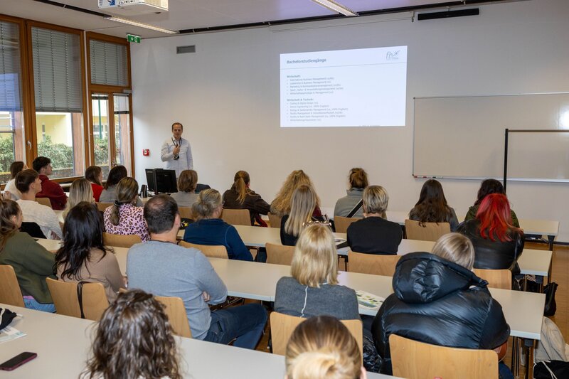 Personen sitzen in einem Hörsaal.