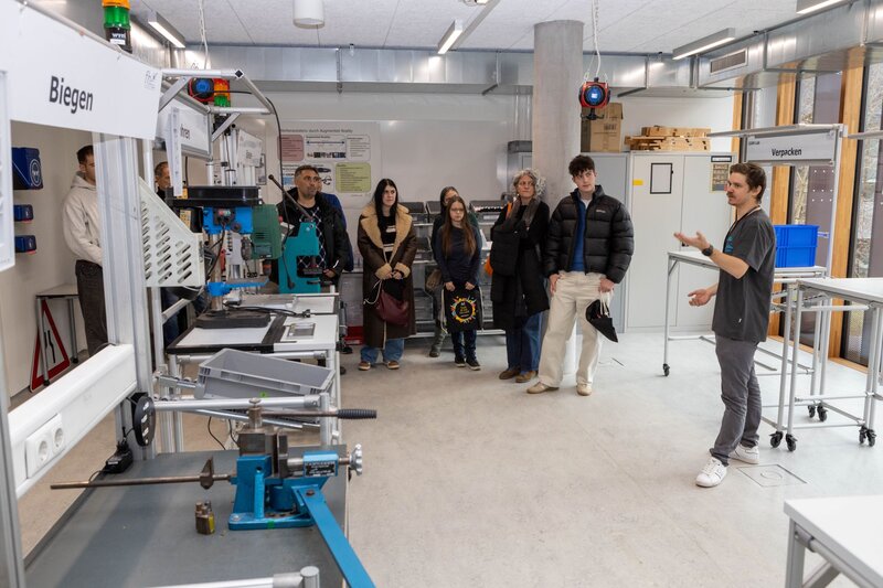 Personen stehen in einem Forschungsraum und blicken auf die Geräte.