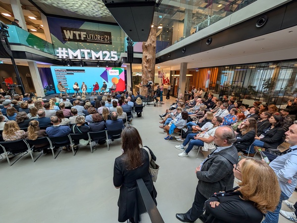 Personen sitzen in einer Aula zur Bühne gerichtet. | © FH Kufstein Tirol