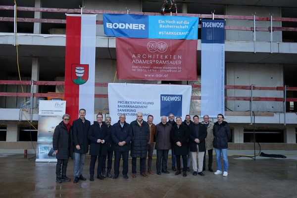 Viele Männer stehen vor einem Rohbau und schauen in die Kamera. | © FH Kufstein Tirol