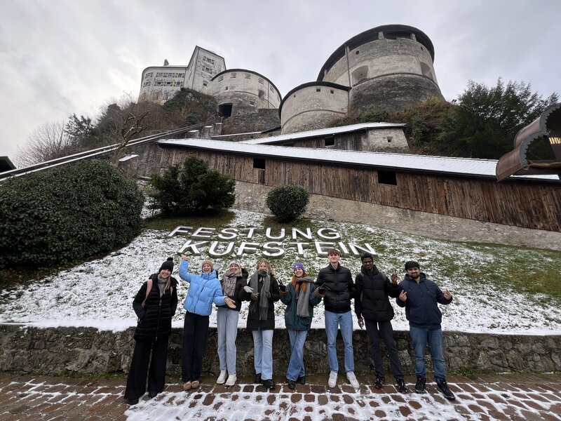 Studierende stehen vor einer Festungsmauer
