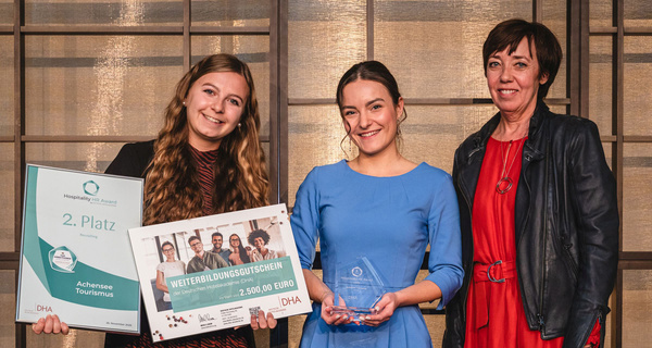 Personen stehen eng nebeneinander und zwei Personen haben Auszeichnungen in der Hand. | © Thomas Loris (DHA)