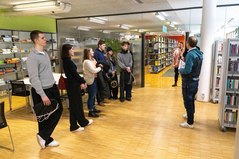 Personen stehen im Eingangsbereich der Bücherei.