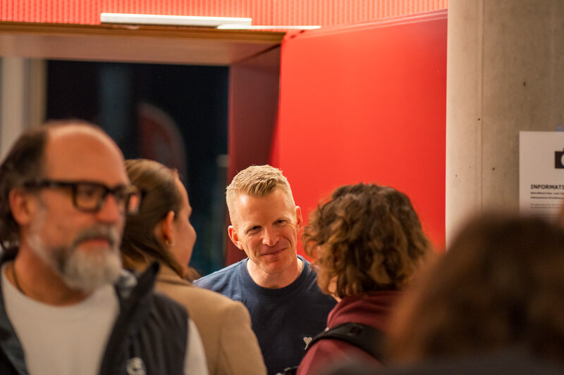 Personen stehen in Gruppen zusammen. 