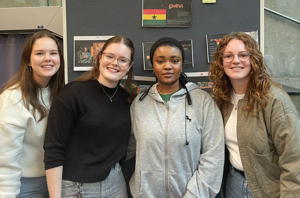 Vier Personen stehen vor einer Pinnwand als Gruppe zusammen. | © privat