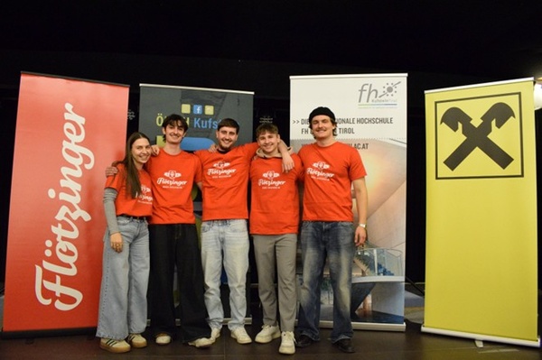Personen mit orangenen Shirts stehen auf einer Bühne | © FH Kufstein Tirol