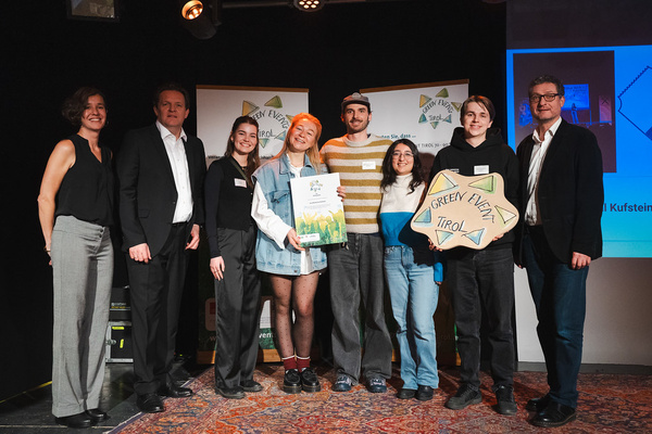 Personen stehen auf einer Bühne nebeneinander und halten ihre Auszeichnungen in die Kamera. | © Nils Lang