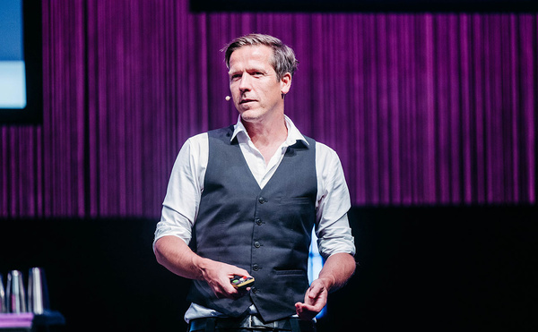 Michael Katzlberger steht auf einer Bühne mit einem lila Bühnenvorhang. | © IAW - Interactive West