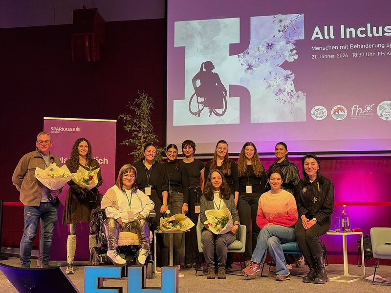 Gäste, Mitglieder des Praxisprojekts und Moderatorin auf der Bühne im Festsaal der FH Kufstein Tirol.
