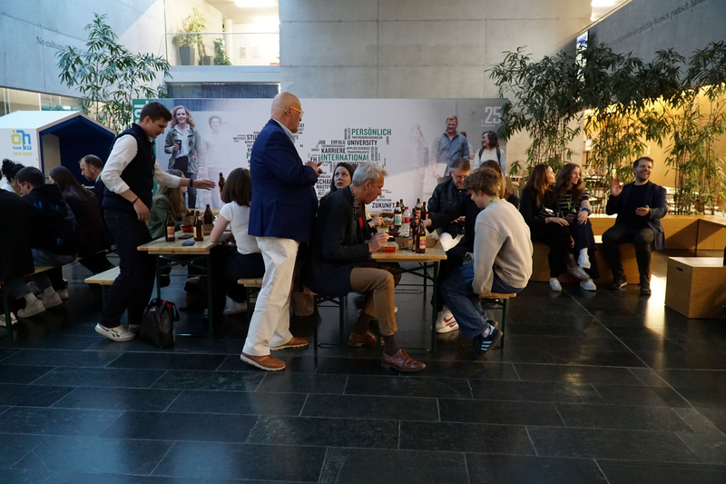 Teilnehmer:innen nehmen einen Snack zu sich in der Aula der FH Kufstein Tirol.
